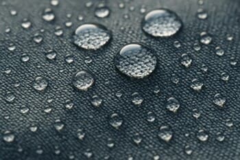 Close-up of outdoor cushion fabric with fine weave above soft green blur