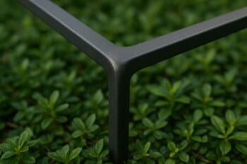 Slim powder-coated metal frame with rounded corner above groundcover plants