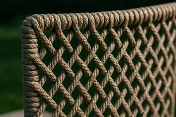 Outdoor rope weave pattern catching small highlights above a dark green lawn