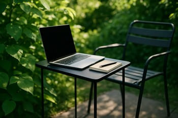Slim outdoor table with a laptop and notebook beside a simple chair