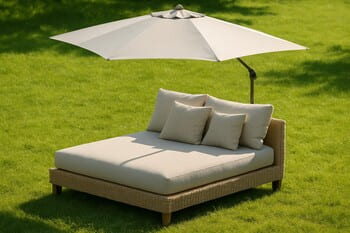 Outdoor daybed under a wide parasol on bright summer grass