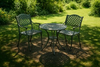 Two chairs placed in a round patch of shade under a small tree
